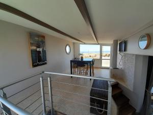 a room with a staircase with a table and a dining room at La palmeraie de brévy in Réville