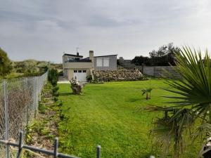 a yard with a fence in front of a house at La palmeraie de brévy in Réville