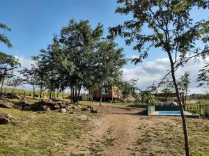 a dirt road leading to a house with trees at Villa Nicolasa in Villa Yacanto