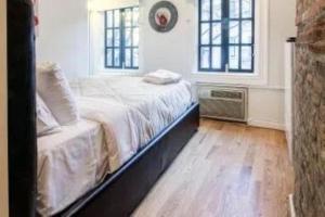 a bedroom with a bed and two windows at Beautiful 3 BR Apartment in New York