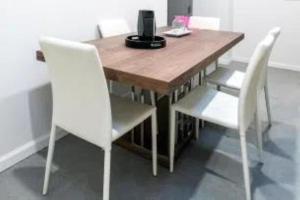 a wooden table with two white chairs and a computer on it at Beautiful 3 BR Apartment in New York