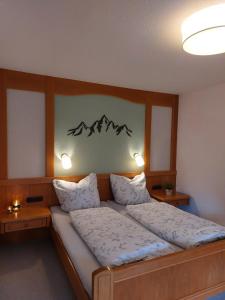 - une chambre avec un grand lit et 2 lampes dans l'établissement Ferienwohnung Bergleuchten, à Obermaiselstein