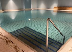 a swimming pool with a staircase in the water at Wasserfall - Zentrum - Balkon - Seeblick - Küche in St. Moritz