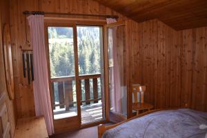 1 dormitorio con cama y ventana grande en Chalet familial pour l'été, en Troistorrents