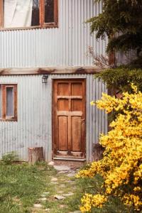 um edifício com uma porta de madeira ao lado em Cabaña Dakota, Ushuaia em Ushuaia