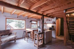 uma cozinha com tecto em madeira e uma mesa com bancos em Cabaña Dakota, Ushuaia em Ushuaia