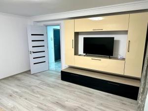 a living room with a flat screen tv on a entertainment center at ELITE APARTMENT in Buzău
