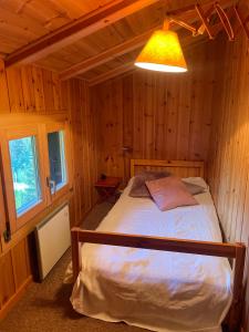 1 dormitorio con 1 cama en una cabaña de madera en Chalet familial pour l'été, en Troistorrents