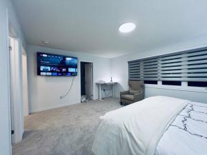 a bedroom with a bed and a tv on the wall at Brand New! Modern Luxury Retreat! in Barrie