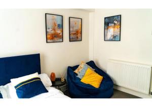 Habitación con cama, sofá y cuadros en la pared. en Clifton’s Cosy Escape en Bristol