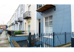 un bâtiment avec une clôture bleue à côté d'une rue dans l'établissement Clifton’s Cosy Escape, à Bristol