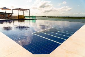 a pool of water with a table and an umbrella at Pousada Vida de Rio in Neópolis