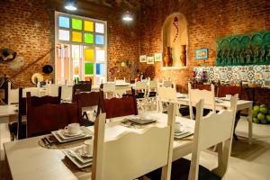 a dining room with white tables and white chairs at Pousada Vida de Rio in Neópolis
