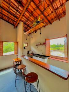 - une cuisine avec un bar et deux tabourets dans l'établissement Reserva do Bosque Hospedaria e Natureza, à Ibicoara