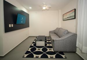 a living room with a chair and a tv at Vista Express Guadalajara Expo in Guadalajara