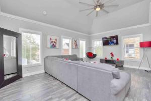 un salon avec un canapé et un ventilateur de plafond dans l'établissement Prolific Red Luxe: Private Deck + Stylish Living, à Houston