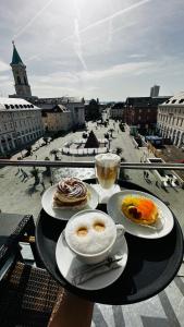 a table with two plates of food and a view of a city at Hotel Am Markt in Karlsruhe