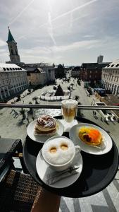 einen Tisch mit 2 Tellern und Stadtblick in der Unterkunft Hotel Am Markt in Karlsruhe