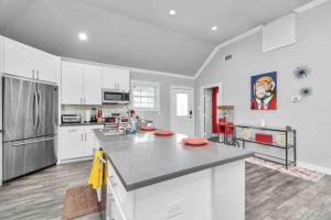 une cuisine avec des armoires blanches et un grand îlot de cuisine dans l'établissement Prolific Red Luxe: Private Deck + Stylish Living, à Houston