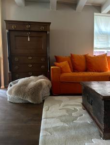 a living room with an orange couch and a dresser at Sterlogies Cityhouse Madame Agaath in Leeuwarden