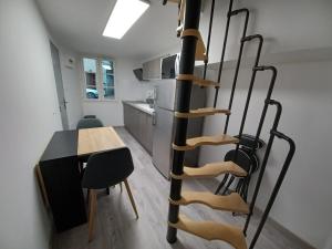 富瓦Charmant T2 duplex Centre de Foix的一间设有桌子和厨房的螺旋楼梯
