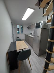 een keuken met een tafel en stoelen en een koelkast bij Charmant T2 duplex Centre de Foix in Foix