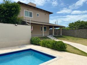 una casa con piscina frente a una casa en Naooo alugo maiss en São Gonçalo do Amarante