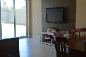 sala de estar con mesa y TV en la pared en Naooo alugo maiss en São Gonçalo do Amarante
