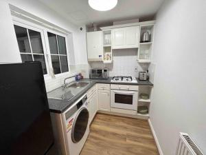 een kleine keuken met een wastafel en een fornuis bij 1 Bed Greater London Flat next to Station & Free Parking in Romford