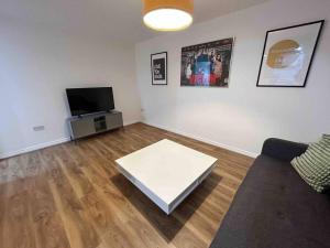 a living room with a couch and a white coffee table at 1 Bed Greater London Flat next to Station & Free Parking in Romford