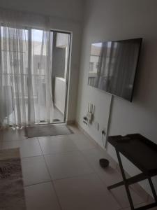 a white room with a large window and a table at Leisure apartment in Ballito
