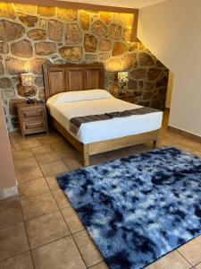 sypialnia z łóżkiem i kamienną ścianą w obiekcie Hotel Jardín del Cantador w mieście Guanajuato