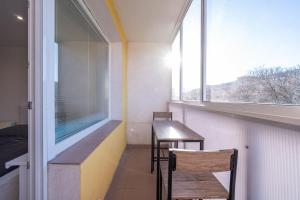 a balcony with two chairs and a table and a window at J Komfortný byt na skok od centra in Košice