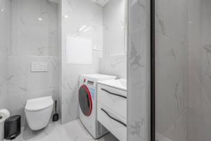 a bathroom with a washing machine and a toilet at J Komfortný byt na skok od centra in Košice