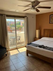 een slaapkamer met een bed en een balkon met een tafel bij Hotel Jardín del Cantador in Guanajuato