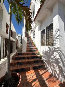 un conjunto de escaleras que conducen a una casa con una palmera en Posada Colonial Beach Villas, en San Juan