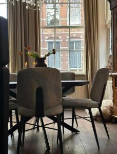 comedor con mesa, sillas y ventana en City House Grande Madame Agaath, en Leeuwarden
