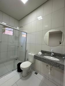a bathroom with a toilet and a shower and a sink at Infinit Hotel Flats in Janaúba