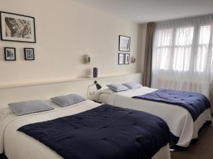 two beds sitting next to each other in a room at Le Téméraire Hôtel in Charolles