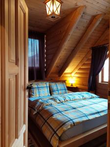 ein Schlafzimmer mit einem Bett in einem Blockhaus in der Unterkunft Apartments Greenstone in Kolašin
