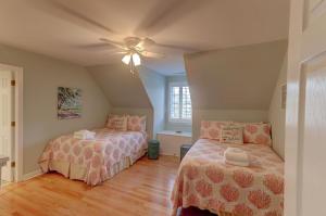 um quarto com 2 camas e uma ventoinha de tecto em 17 56th Avenue em Isle of Palms