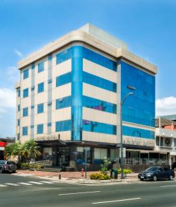 un edificio azul y blanco en una calle de la ciudad en Airport Hotel Guayaquil en Guayaquil