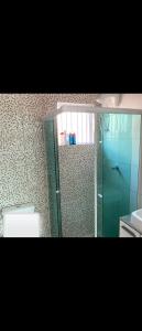 a bathroom with a glass shower and a toilet at Casa temporada cananeia in Cananéia