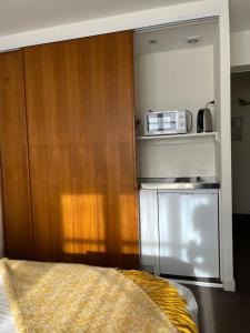 eine kleine Küche mit einer Mikrowelle und einem Kühlschrank in der Unterkunft Le Téméraire Hôtel in Charolles