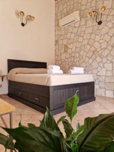 a bedroom with a bed and a stone wall at La Chiusazza in Case Monterosso
