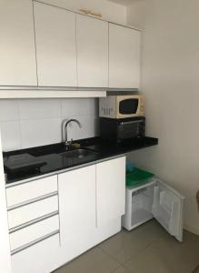 eine Küche mit einer Spüle und einer Mikrowelle in der Unterkunft Studio Park in Montevideo
