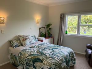 a bedroom with a bed and a window at Perma Ridge Farmstay in Ngaruawahia