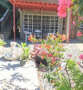 um jardim com flores em frente a um edifício em Ixtapa Playa Linda Hostel em Barrio Nuevo