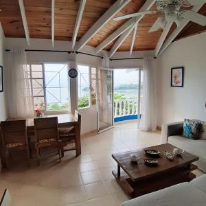 BLUE HOUSE OCEAN VIEW في سانتا باربرا دو سامانا: غرفة معيشة مع طاولة وأريكة وطاولة
