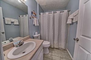 a bathroom with a sink and a toilet and a shower at Pineapple Villas in Panama City Beach